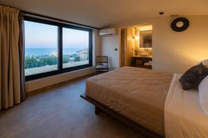 赫索尼索斯玛尔尼乡村酒店的一间卧室设有一张大床和一个大窗户