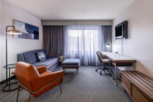 盐湖城盐湖城机场万怡酒店的带沙发和书桌的酒店客房