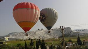 帕莫卡莱Hotel Goreme Sakura的两架热气球飞越高山