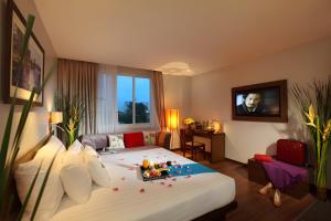胡志明市Silverland Sakyo Hotel的酒店客房设有一张大床和一台电视。