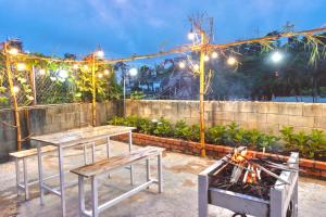 大叻Cloud River Homestay的庭院设有2张桌子和带灯的烧烤架。