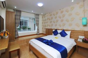 胡志明市Ailen Hotel的一间卧室配有一张蓝色弓床