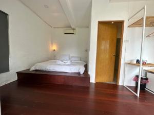 达叻府Capital O 75411 Navagio​ boutique​ Koh​ Chang​的卧室配有白色的床,铺有木地板