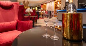 科隆PLAZA Premium Köln的一张桌子,上面放着一瓶香槟和两杯酒杯
