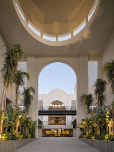 赫尔格达Serry Beach Resort的开放式大堂拥有棕榈树和大窗户