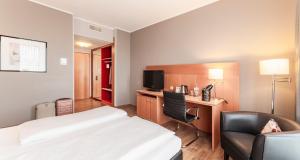科隆PLAZA Premium Köln的配有一张床和一把椅子的酒店客房