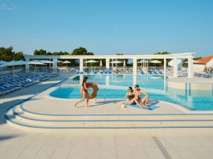 图彻皮布鲁萨阿尔加酒店的一群人坐在游泳池周围