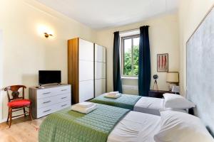 米兰Appartamento Napoli 25 - Affitti Brevi Italia的一间卧室设有两张床、一台电视和一扇窗户。