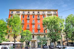 米兰Appartamento Napoli 25 - Affitti Brevi Italia的一座橙色的建筑,前面有汽车停放
