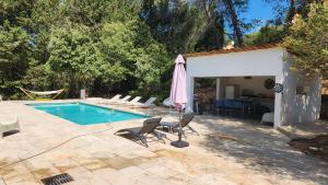 洛尔格La Bastide Blanche Magnifique villa 5 étoiles 5 chambres et piscine privée sur 6500 m VAR的一个带椅子和遮阳伞的游泳池以及一间房屋