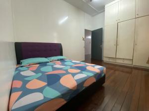 拉布安Ayana Homestay的一间卧室配有一张带五颜六色棉被的床