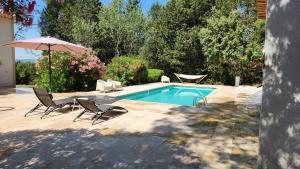 洛尔格La Bastide Blanche Magnifique villa 5 étoiles 5 chambres et piscine privée sur 6500 m VAR的一个带两把椅子和遮阳伞的游泳池