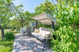派尔努Fantastic 170m2 Villa with a big garden的一个带沙发和白色遮阳伞的庭院