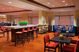 多伦多多伦多机场万怡酒店的餐厅设有酒吧和桌椅