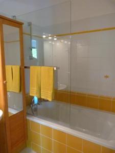 Salles-la-SourceLa Désirade的浴室配有浴缸、淋浴和黄色毛巾