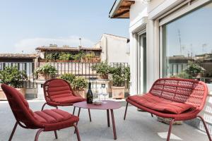 罗马Palazzo Delle Pietre - Luxury Apartments的阳台的天井配有2把椅子和1张桌子