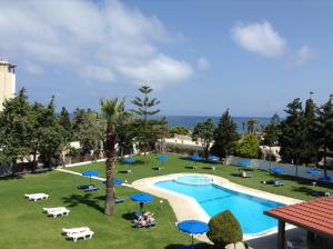 伊利索斯玛图拉海滩酒店的享有带蓝伞的游泳池的景色