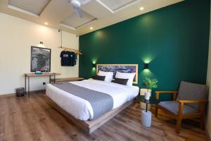 锡卡都LOKAL Rooms x Skardu (Mountain View)的一间卧室设有一张大床和绿色的墙壁