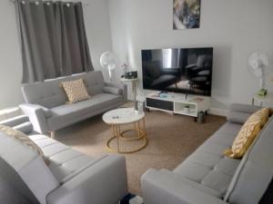 Cosy & Spacious 4 Bedroom House with Free Parking in Birmingham的客厅配有两张沙发和一台电视机