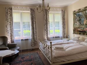 ChludowoMleczarnia Hotel Restauracja的一间卧室设有两张床、一张沙发和窗户。