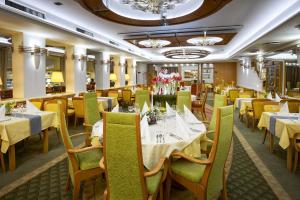 罗斯诺夫·波德·拉德霍斯滕艾尔罗普兰康体酒店的一间设有白色桌子和黄色椅子及桌子的餐厅