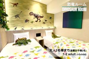 仙台Henn na Hotel Sendai Kokubuncho的带壁画的恐龙客房的两张床