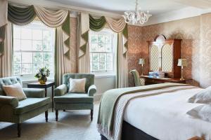 伦敦戈林酒店的一间卧室配有一张床、两把椅子和窗户