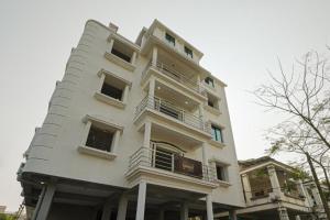 布巴内什瓦尔Goroomgo Grace Premium Bhubaneswar的白色的建筑,旁边设有阳台