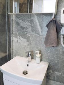 华沙Irisapart A65的浴室配有白色水槽和淋浴。