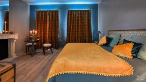 Vieil-HesdinManoir Marceau的一间卧室配有一张带蓝色墙壁的大床