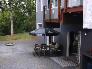 布卢梅瑙Hostel SIL CARDOSO的露台配有桌椅和遮阳伞