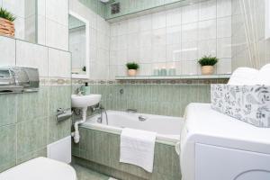 卡利什Apartament Nowy Świat 15-17的带浴缸、盥洗盆和卫生间的浴室