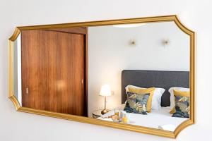 波尔图Wine Apartments的卧室内的镜子反射着一张床