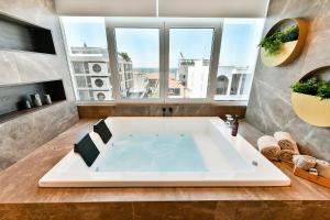 塞萨洛尼基Porto Sea View Apartments的带窗户的浴室设有大浴缸