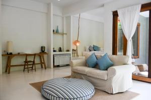 湄林普劳德普发希普与格林度假酒店的客厅配有白色沙发和蓝色枕头。