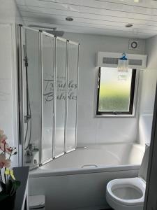 塞顿港No 1 The Glen的白色的浴室设有浴缸和卫生间。