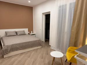 特拉帕尼Casa AnnaBella的一间卧室配有一张床和一张黄色椅子