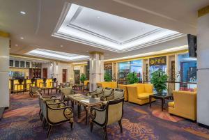 泰安东尊华美达大酒店的配有桌椅和黄色椅子的餐厅