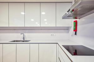 科英布拉Avenue Garden的白色的厨房配有白色橱柜和水槽