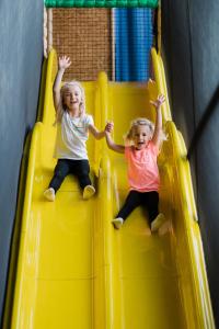阿尼夫动量酒店的两个小女孩滑下黄色滑梯
