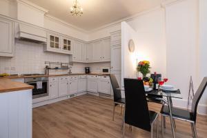 伦敦Stay Thames River的厨房配有白色橱柜和桌椅