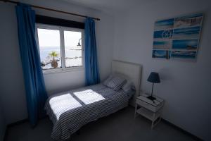 蓬塔穆赫雷斯Casa La Seba的一间卧室设有一张床和一个享有海滩美景的窗户。