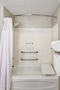 坦培凤凰城天普机场春季山丘套房酒店的带淋浴和白色淋浴帘的浴室