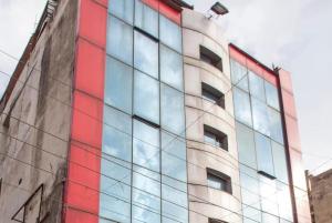 贾姆穆Hotel Novelty的一座高大的建筑,拥有红色和蓝色的窗户