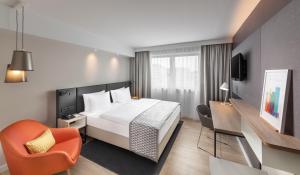 慕尼黑慕尼黑市中心假日酒店的配有一张床和一把椅子的酒店客房