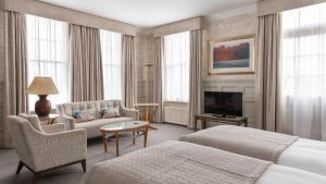 奥尔德堡温特沃斯酒店的酒店客房设有两张床、一张沙发和一台电视。