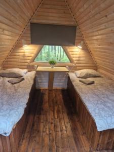 RõmedaLiivakõrtsi kämping的木间设有两张床,设有窗户