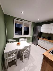 齐斯纳Apartament Wrzos的厨房配有白色的桌子和冰箱。