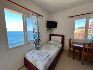 萨兰达Prive Hill Saranda的卧室配有床、桌子和窗户。