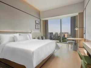 广州广州白云国际会议中心越秀源宿酒店（广交会期间免费穿梭巴士至展馆）的酒店客房设有白色的床和大窗户。